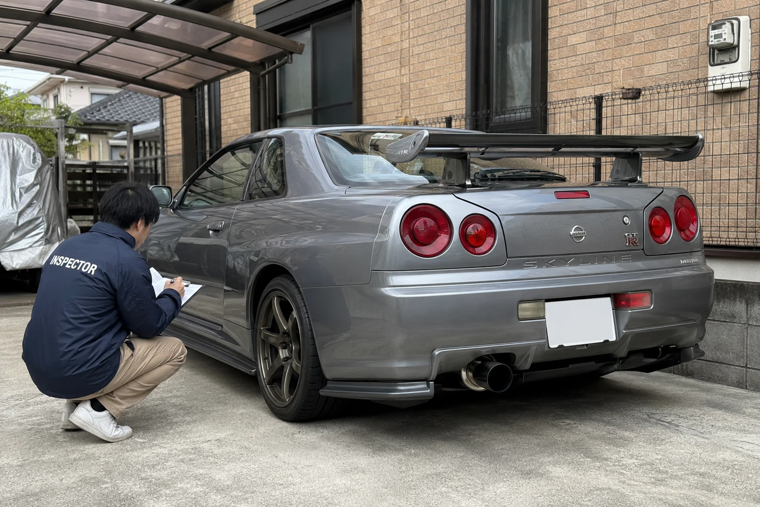 スカイラインGT-Rの後方を査定するスタッフ